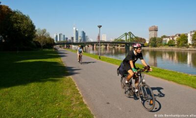 A cyclist rides on the Main Cycle Path with the Frankfurt skyline in the background.